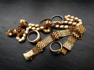 Goldschmuck mit Ringen und Armbändern auf dunklem Hintergrund