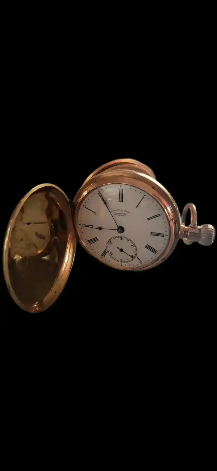 Geöffnete goldene Taschenuhr mit weißem Zifferblatt
