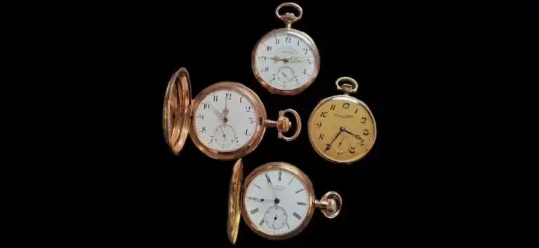 Vier antike goldene Taschenuhren auf schwarzem Hintergrund