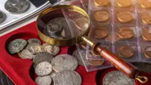 Alte Münzen mit Lupe auf rotem Samt